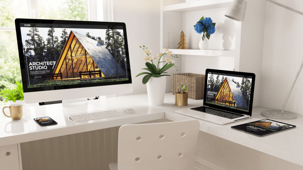 A computer, laptop, and tablet arranged neatly on a desk, showcasing CMS web design & development services.